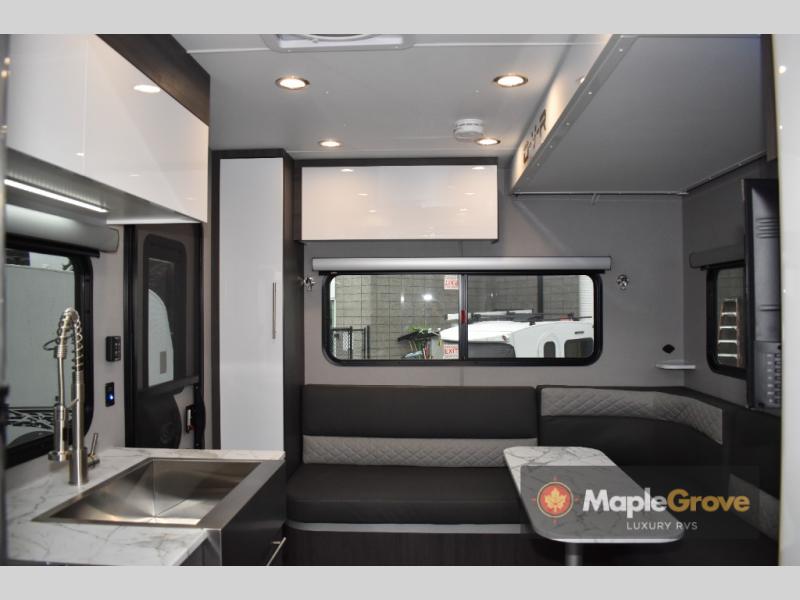 inTech RV O-V-R Expedition interior view of the L-shaped sofa and dinette table